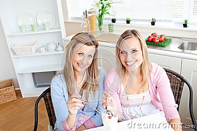 Delighted friends eating an ice cream and smiling Stock Photo