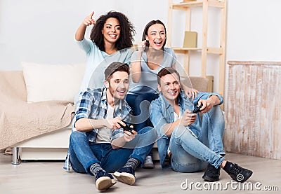 Delighted friends playing video games Stock Photo