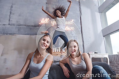 Delighted girl jumping and having fun with friends Stock Photo