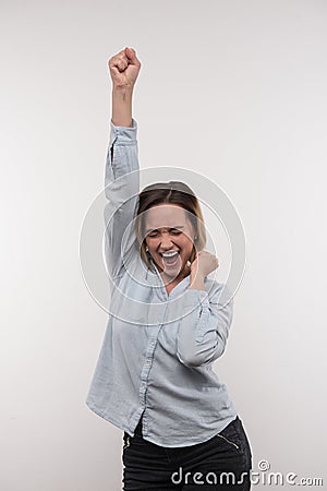 Delighted happy woman holding her arm up Stock Photo