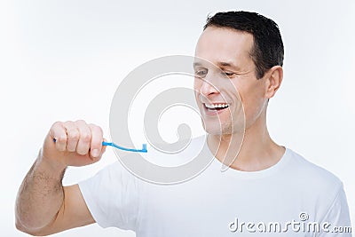 Delighted nice man looking at his toothbrush Stock Photo