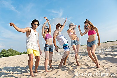 Delighted overjoyed friends standing on the beach Stock Photo