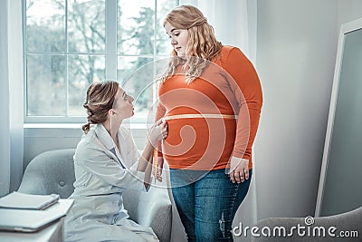 Delighted oversized woman listening to her dietician Stock Photo