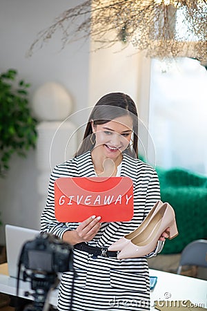 Delighted popular blogger giving shoes for free Stock Photo