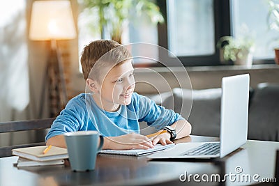 Delighted positive boy enjoying studying Stock Photo