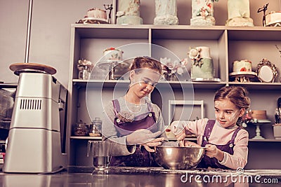 Delighted positive girls trying to make the dough Stock Photo