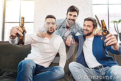 Delighted positive men cheering for you Stock Photo