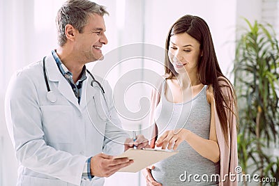 Delighted pregnant woman asking about diagnosis Stock Photo