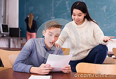 Delighted teenager and Chinese girl schoolmate reading notification Stock Photo