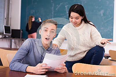 Delighted teenager and Chinese girl schoolmate reading notification Stock Photo