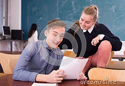 Delighted teenager and female schoolmate reading notification Stock Photo