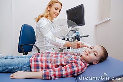 Delighted young practitioner providing ultrasound examination in the clinic Stock Photo