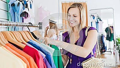 Delighted young woman choosing clothes Stock Photo