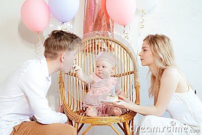 Delightful happy, festive full family of man and woman care about child feeding father by present cake sitting on chair Stock Photo