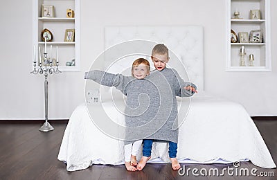Delightful little children in big grey sweater. Stock Photo