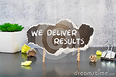 We deliver Results text on a black folder near a cup of coffee. light wooden background Stock Photo