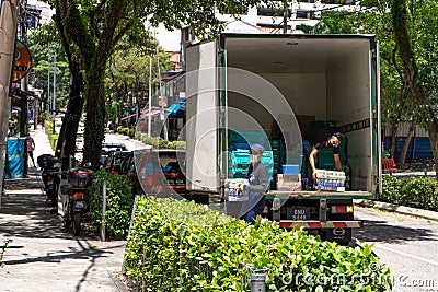 Deliveries of goods to stores unload boxes of drinks from the truck Editorial Stock Photo