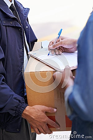 Delivering direct to your door. A friendly delivery man delivering a package to a home. Stock Photo