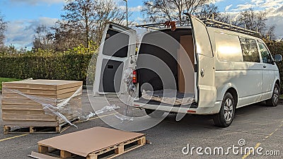 Delivering and unloading pallets of boxes out of a white van Stock Photo