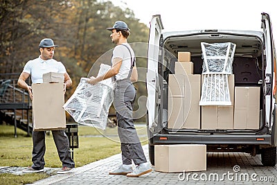 Delivery company employees unloading cargo van vehicle Stock Photo