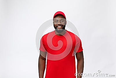 Delivery Concept - Handsome African American delivery man. Isolated on Grey studio Background. Copy Space Stock Photo