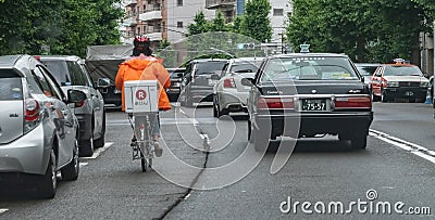 Delivery Cyclist In Tokyo Street, Japan Editorial Stock Photo