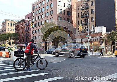 Delivery cyclist waiting at red light in Hell`s Kitchen Editorial Stock Photo