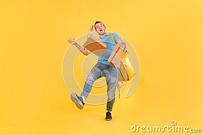 Delivery guy in blue uniform slipped and lost his balance and threw boxes of food from restaurant in direction. Clumsy Stock Photo