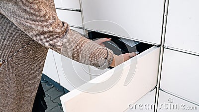 Delivery locker. Post automat terminal and hands with parcel courier box. Online purchase delivery service concept. Stock Photo