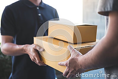 Delivery mail man giving parcel box to recipient, Young owner accepting of cardboard boxes package from post shipment, Home Stock Photo