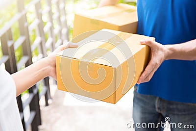 Delivery man in blue uniform handing parcel box to recipient Stock Photo