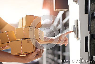 Delivery man holding parcel boxes and ring the doorbell on the client`s door in the morning background Stock Photo