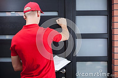 Delivery man knocking on the client's door Stock Photo