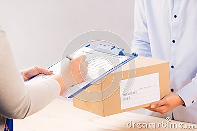 Delivery man presenting receiving form in post office Stock Photo