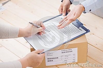 Delivery man presenting receiving form in post office Stock Photo