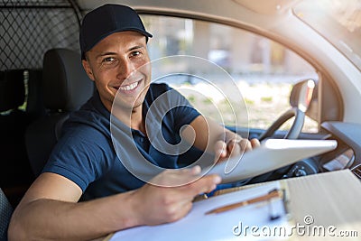 Delivery man sitting in a delivery van Stock Photo