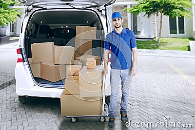 Delivery man with trolley and car Stock Photo