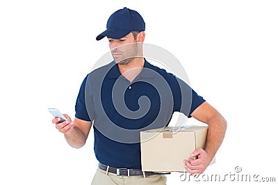 Delivery man using mobile phone while holding package Stock Photo