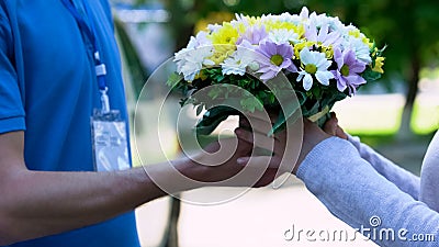 Delivery man giving bouquet to woman, easy order and delivery of flowers service Stock Photo
