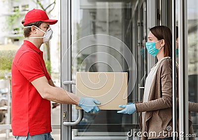 Girl opens door and takes box from the courier, in protective mask and gloves Stock Photo