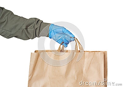 Delivery person hand wearing rubber glove holding paper bag isolated on white background. Safe shopping Stock Photo