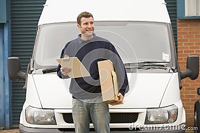 Delivery person standing with parcel and clipboard Stock Photo