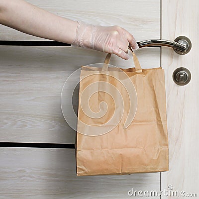 Delivery during the quarantine. Grocery store shopping delivery man giving paper bag with Merchandise, goods and food Stock Photo