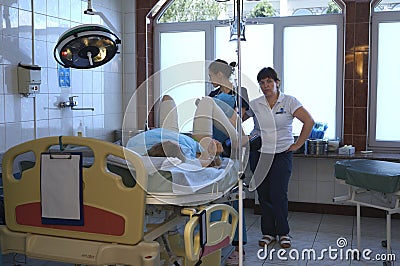 At the delivery room. Woman giving birth lying in the chair, doctors ready to deliver baby Editorial Stock Photo