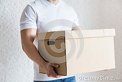 Delivery strong, muscular man loading cardboard boxes for moving to an apartment. professional worker of transportation Stock Photo