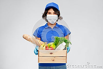 Delivery woman in face mask with food in box Stock Photo