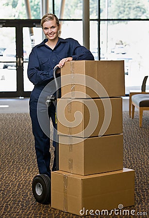 Delivery woman posing with stack of boxes Stock Photo