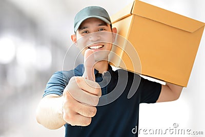 Deliveryman carrying a box, giving thumbs up Stock Photo