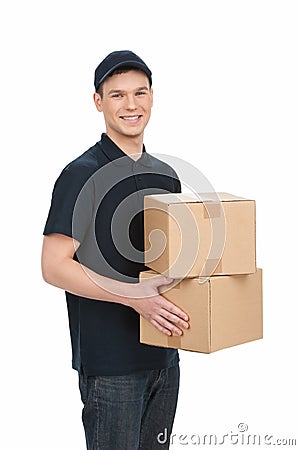 Deliveryman at work. Cheerful young deliveryman holding a box st Stock Photo