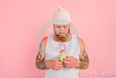 Delusion man with beard and tattoos acts like a small newborn Stock Photo